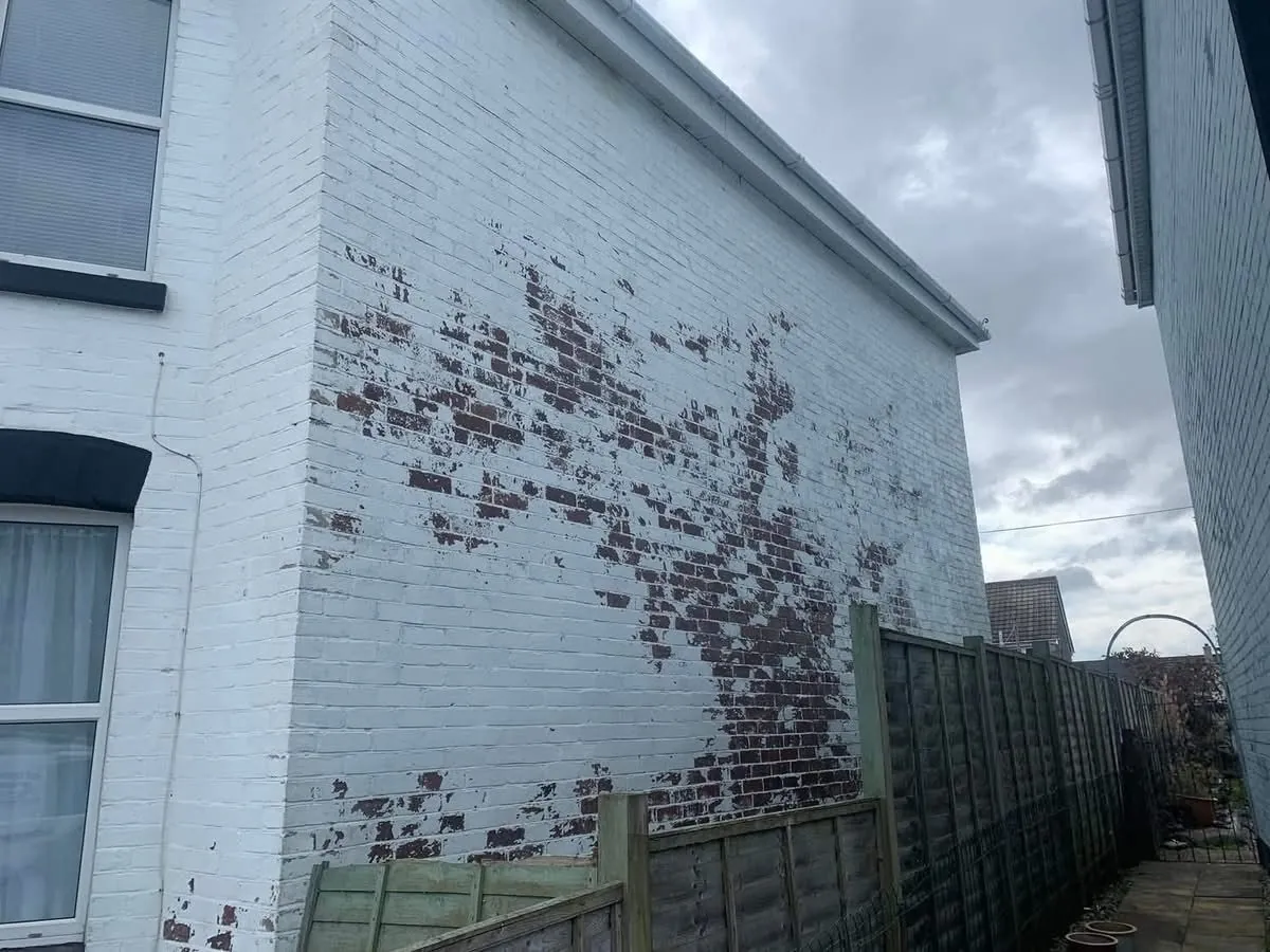 Peeling paint on a brick wall before redecoration in St Ives